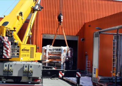 Schwerlastkran hievt 20 Tonnen schwere Flexo-Druckmaschine bei Riba in den Halleneingang