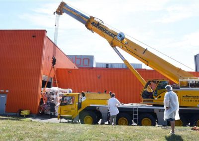 Schwerlastkran hievt 20 Tonnen schwere Flexo-Druckmaschine bei Riba in den Halleneingang